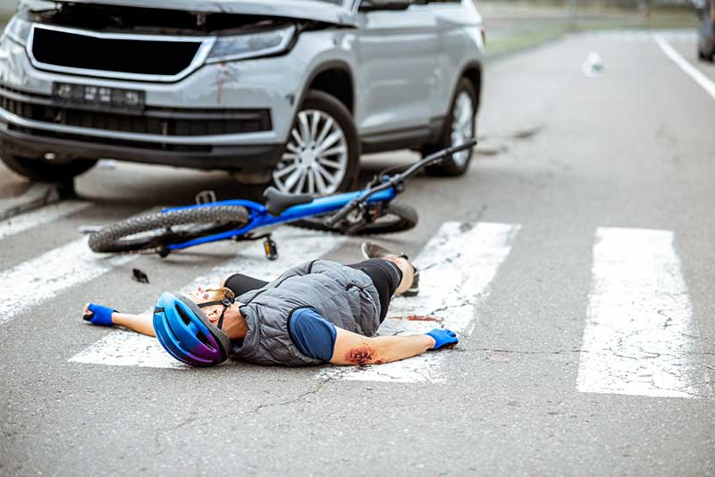 A man on a bicycle that was hit by a car