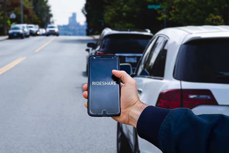 A person holding a phone with Rideshare displayed