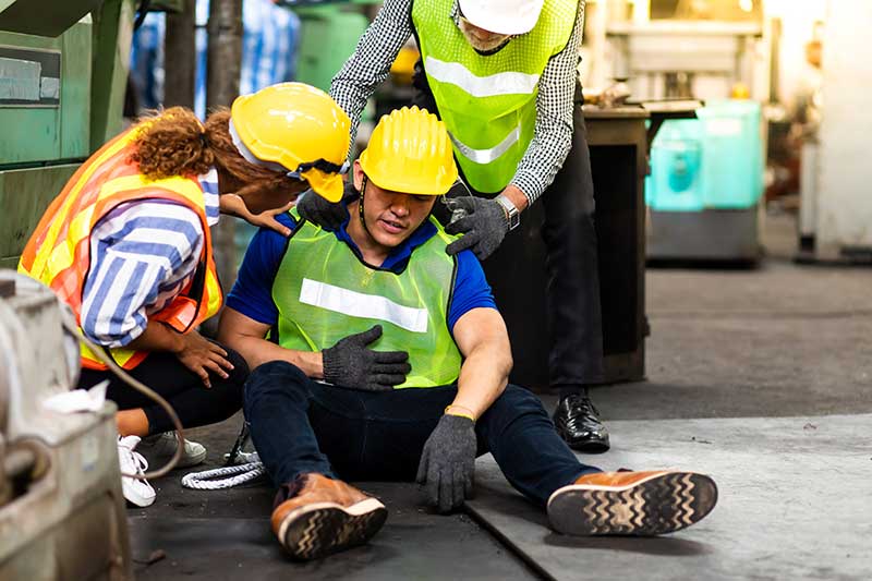 A construction worker sitting on the ground injured