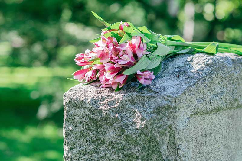 A headstone with flowers on top
