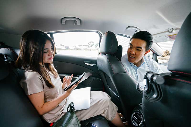 A woman in the back of an Uber/Lyft